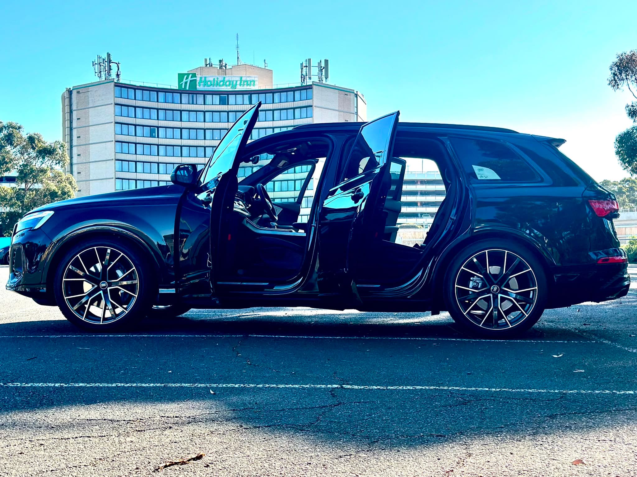 A chauffeur beside a luxury car